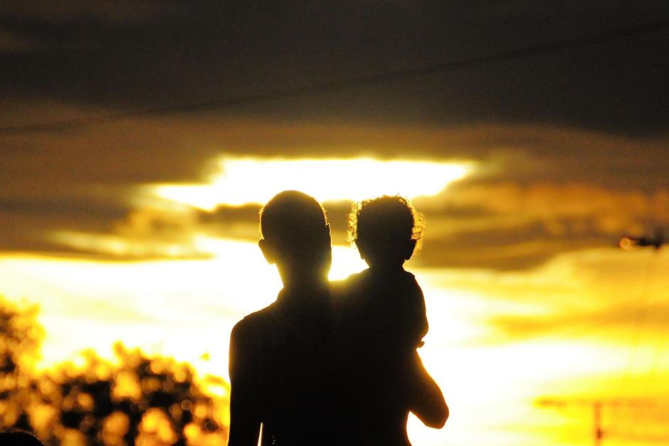A photo submitted to the ABC by Rachel Mcdowall of a personal holding a child, siloietted against a yellow sunset